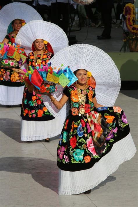 Two Women In Colorful Dresses Holding Parasols On Their Heads And
