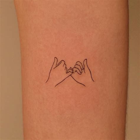 fine line style pinky promise tattoo done on the inner