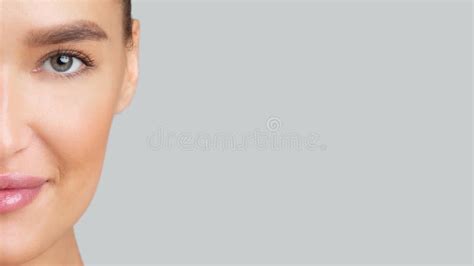 Half Face Portrait Of Woman Looking At Camera At Studio Stock Photo
