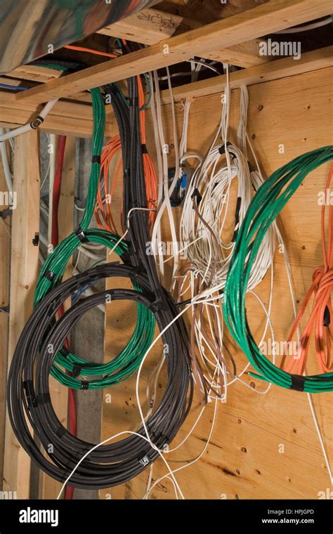 Assorted Wires Hanging From Opened Ceiling Inside A Home Stock Photo