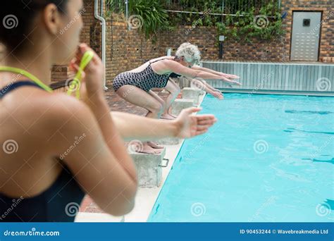 Female Trainer Whistling While Senior Women Diving Into Pool Stock Photo Image Of Dive People