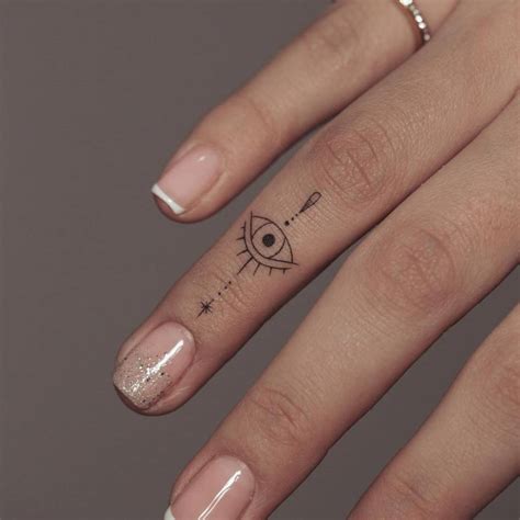 fine line evil eye tattoo on the finger