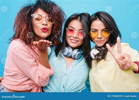 Three Brunette Ladies In Sunglasses Sending Air Kisses On Blue