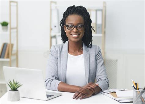Successful Black Businesswoman Smiling Sitting At Workplace In Modern