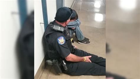 Police Officer Sits On Floor To Comfort Crying Middle School Student