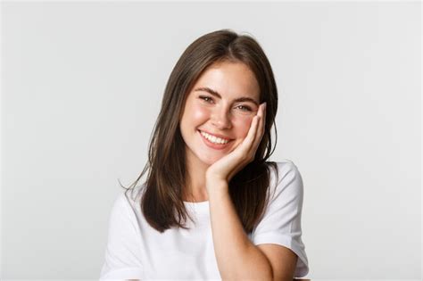 Premium Photo Close Up Of Beautiful Smiling Brunette Girl Touching Cheeks Blushing Over White