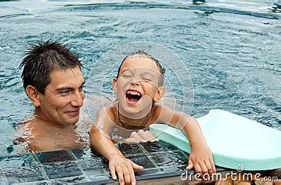 Father And Son Playing In A Swimming Pool Stock Photos Image