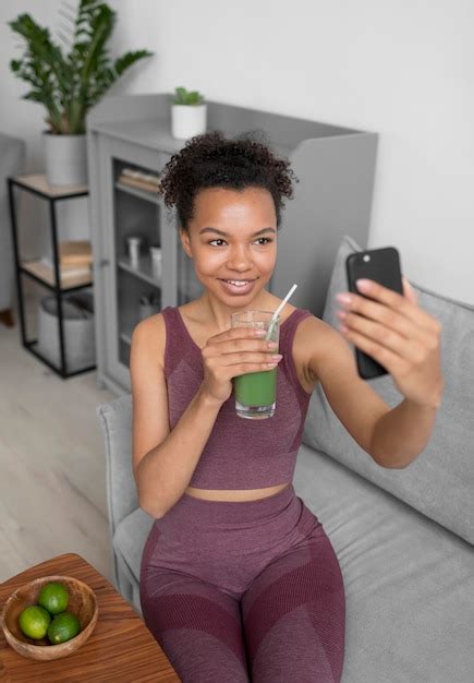 Mulher Fitness Tirando Uma Selfie Enquanto Toma Um Suco De Fruta Foto Grátis