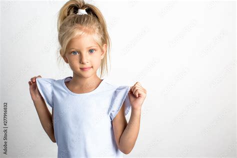 Beautiful Girl With Blond Hair In A Blue Dress A 7 Year Old Child