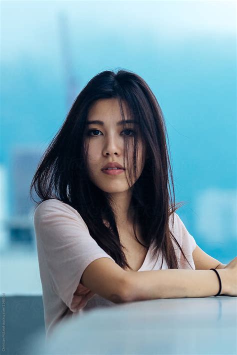 Young Girl In Hong Kong Caught Enjoying The View From A Rooftop Del Colaborador De Stocksy