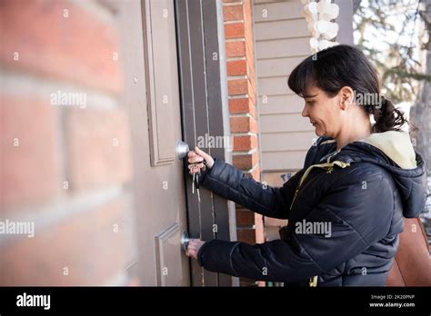 Woman Opening Front Door With Key Stock Photo Alamy