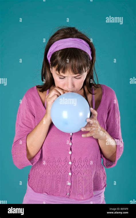 Girl Blowing Up A Balloon Stock Photo Alamy