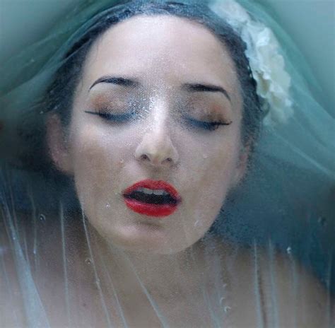 girl with veil over face and red lipstick in water beauty veil over face dark beauty