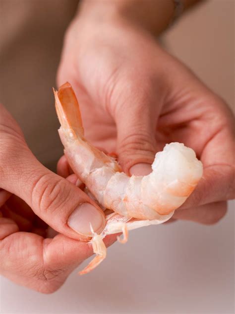 A Person Is Holding Shrimp In Their Hands