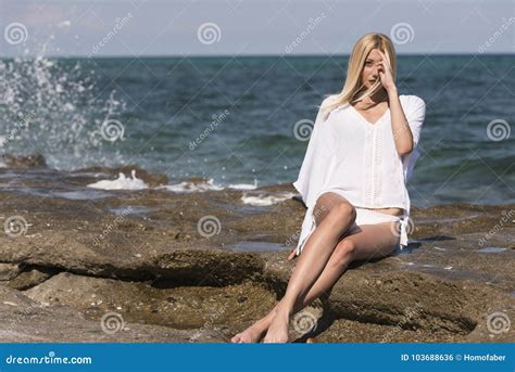 Tall Slim Blonde Woman Wear White Sexy Bikini Sitting On Rocks Waves