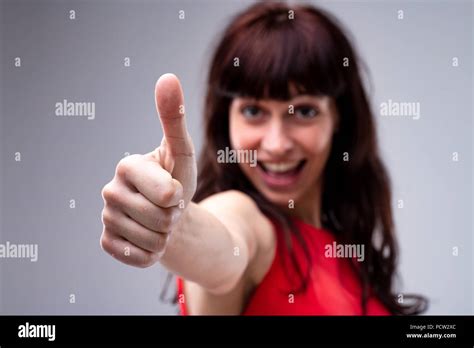 Motivated Young Woman Giving A Thumbs Up Gesture Of Approval And