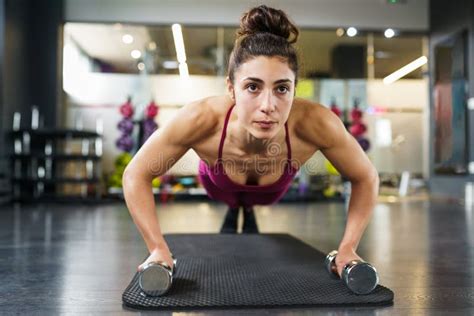 Woman Doing Push Ups Exercise With Dumbbell In A Fitness Workout Stock