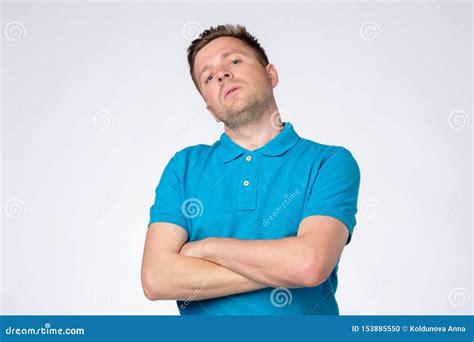 Man Posing In Studio With Arms Crossed And Staring At Camera With