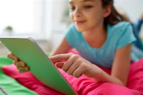 Smiling Girl With Tablet Pc Lying On Bed At Home Stock Photo Image Of