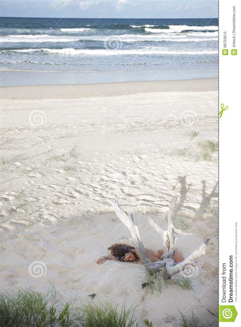 Giovane Signora Nuda Che Dorme In Sabbia Sulla Spiaggia Immagine Stock