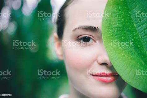 Close Up Portrait Of A Beautiful Young Woman She Uses Large Leaves