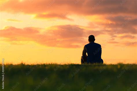 Man Sitting Alone Watching The Beautiful Sunset Stock Photo Adobe Stock
