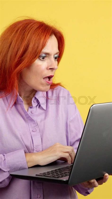 redheaded mature woman with a surprised look using a laptop stock video colourbox