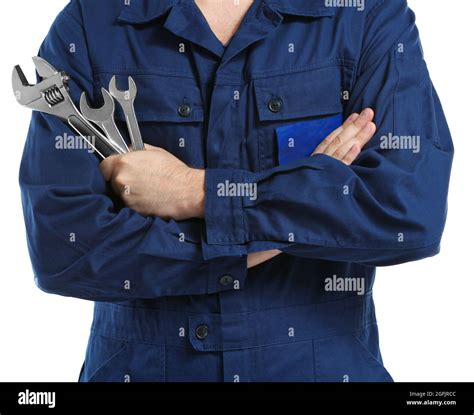 Mechanic In Uniform With Crossed Arms And Wrenches Standing On White