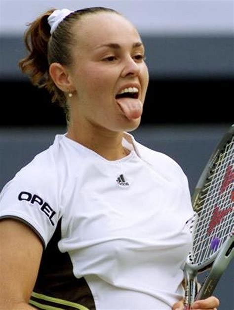 A Woman Holding A Tennis Racquet On Top Of A Tennis Court With Her