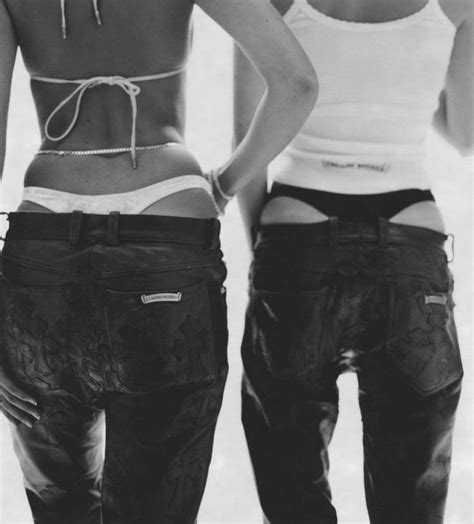 Two Women Standing Next To Each Other With Their Backs Turned Towards The Camera Both Wearing