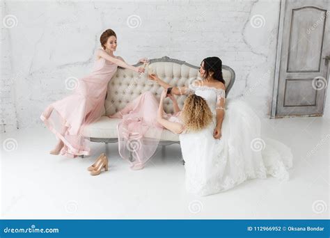 Brides Taking Selfie While Playing On Sofa And Drinking Champagne Stock