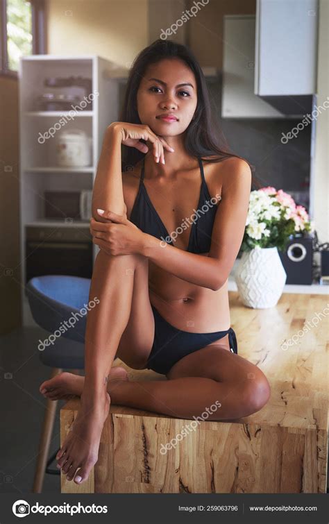 Sexy Asian Girl Sitting On The Table And Relax In Kitchen At Home Stock Photo By Romablack