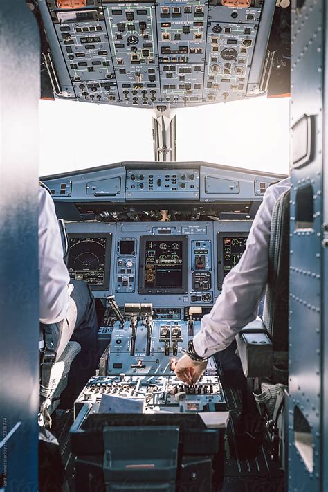 Pilot And Copilot Inside A Cabin Flying An Airplane By Stocksy