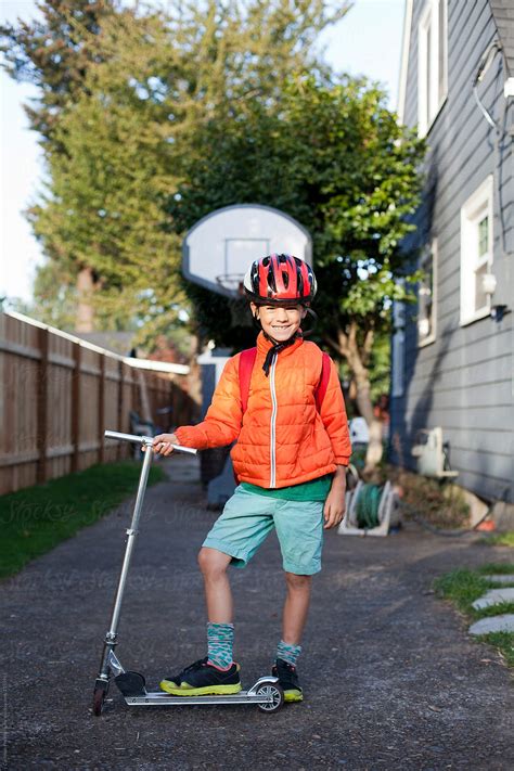 Seven Year Old Boy Is Ready To Go To School On His Scooter By Stocksy
