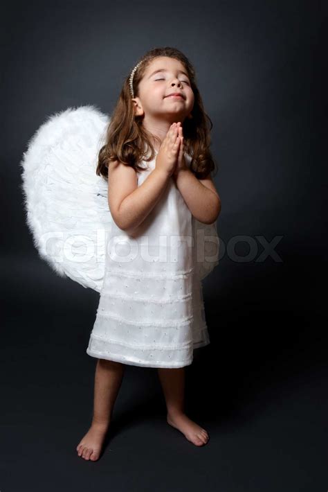Little Barefoot Angel In White Dress And Feathered Wings With Hands