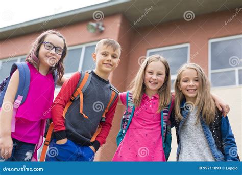 Great Portrait Of School Pupil Outside Classroom Carrying Bags Stock