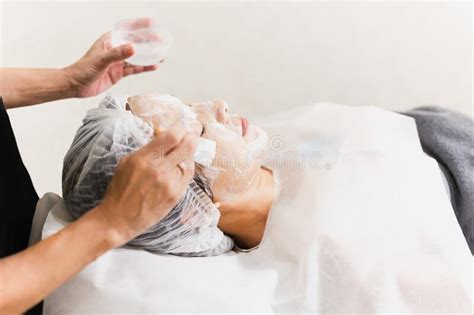 Beautician Hands Making Anti Age Procedures Applying Foam Cleansing Mask For Mid Aged Female