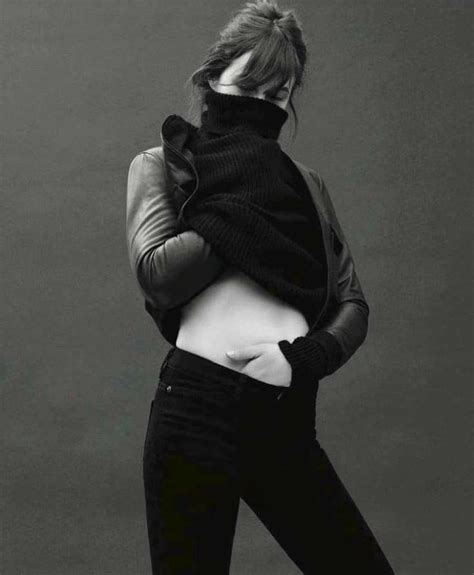 Black And White Photograph Of Woman In Turtle Neck Sweater Jeans And Boots With Hands On Hips