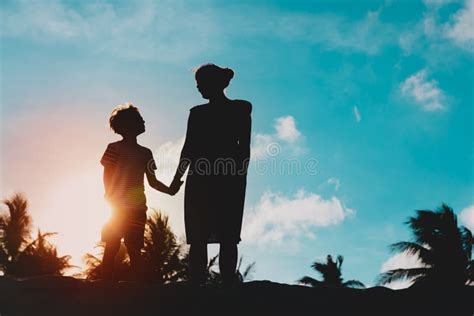 Silhouette Di Madre E Figlio Che Tengono Per Mano Il Tramonto Immagine
