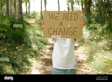 Anonymous Child Displays Sign With The Message We Need A Change Stock