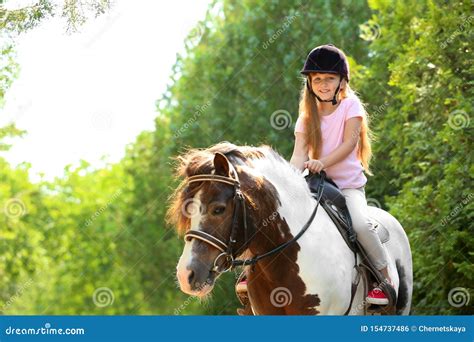 Cute Little Girl Riding Pony In Park Stock Photo Image Of Breed