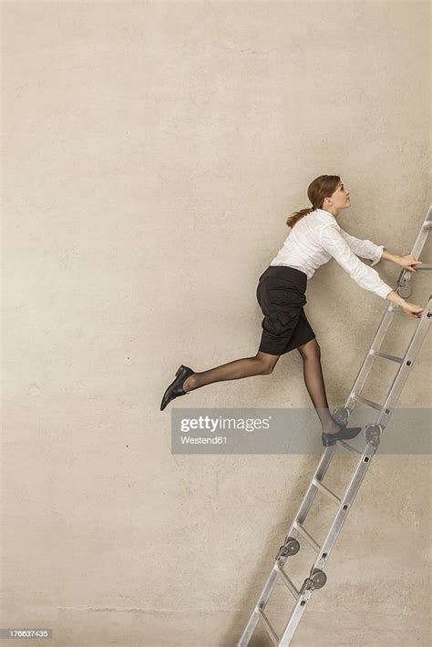 Businesswoman Climbing Ladder In Office Photo Getty Images