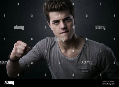 Young Aggressive Man Showing Fists And Looking At Camera Stock Photo