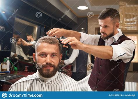 Man Sitting In Chair In Barber Shop During Process Of Haircut Stock 