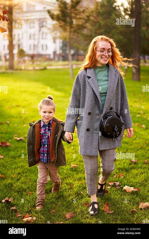 Lächelnde Rothaarige Frau Und Kleiner Junge Die Am Warmen Herbsttag Auf Dem Grünen Rasen Im