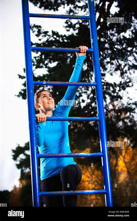 Woman Climbing On Ladder Stock Photo Alamy