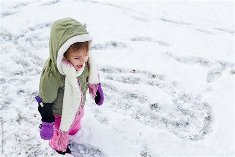 Close Up Of Toddler Girl In Winter Gear Playing Outside In Snow By