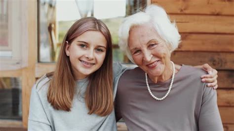 Beautiful Grandmother And Granddaughter Smiling And Posing For Camera