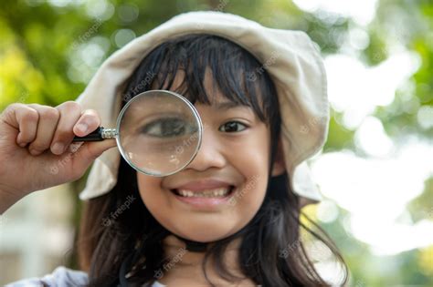 premium photo girl looking through a magnifying glass