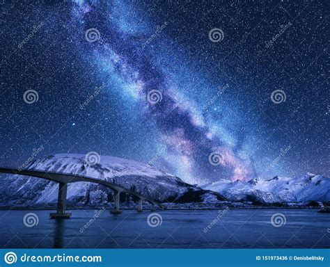 Bridge And Starry Sky With Milky Way Over Snow Covered Mountains Stock